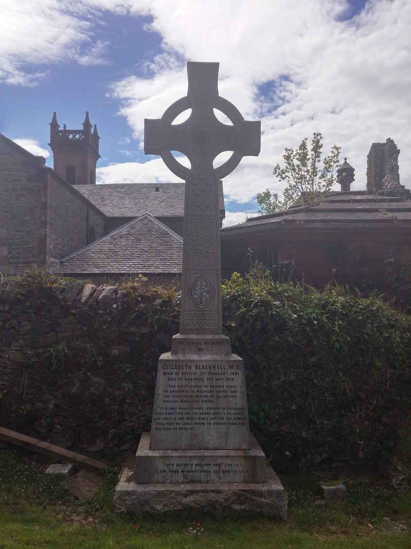 A Celtic cross gravestone to Elizabeth Blackwell with a church in the background