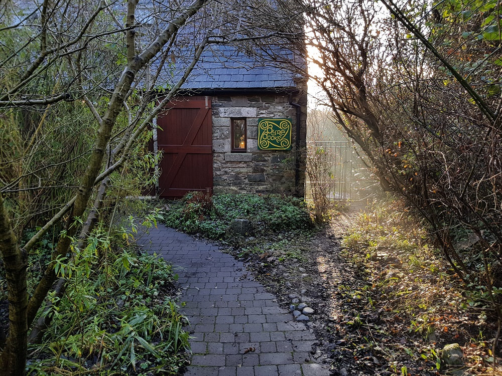 A pathway leading to a stone building with a sign reading 'Byre Books'