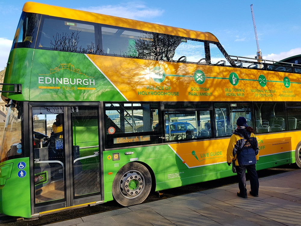 A green and yellow open top bus with the words Edinburgh Tour