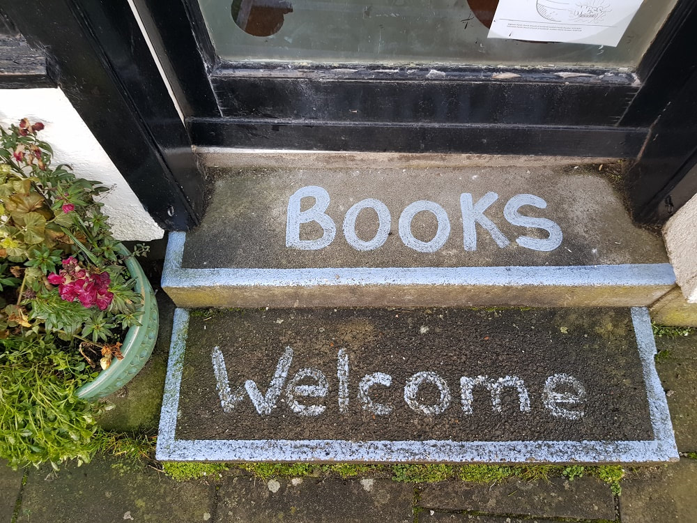 Two stone steps with the words 'Books' and 'Welcome' written on them