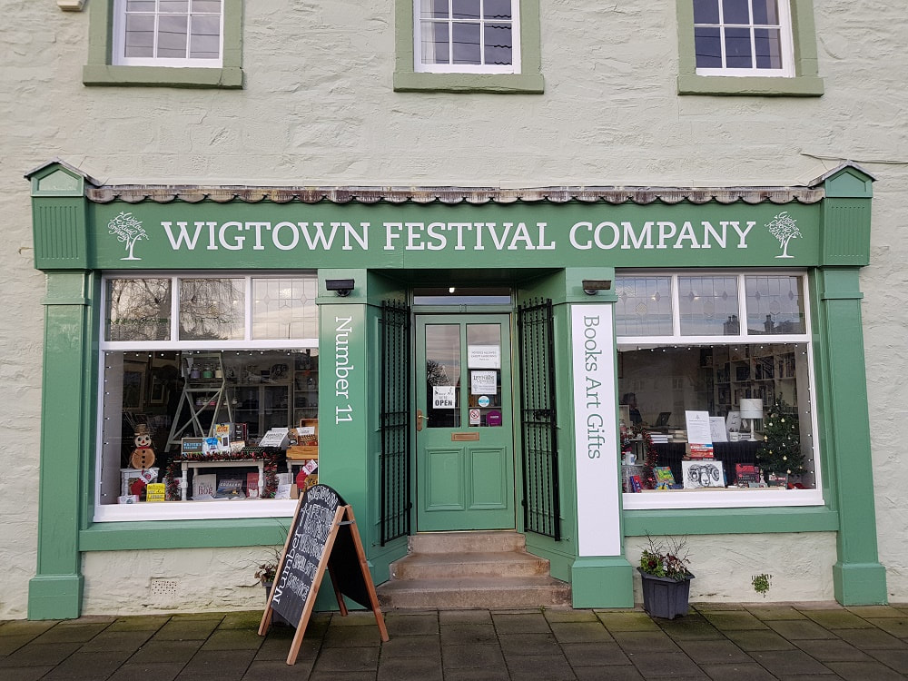 A green shop front with the sign 'Wigtown Festival Company'